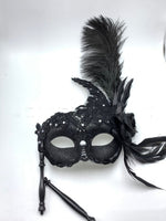 Mascarade vénitienne tenant un masque de plumes demi-visage