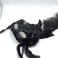 Mascarade vénitienne tenant un masque de plumes demi-visage