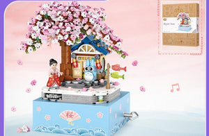 Ensembles de blocs de construction de boîte à musique rotative avec château et arbre en fleurs de cerisier