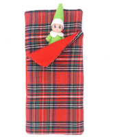 Vêtements de sac de couchage à carreaux pour poupée elfe sur une étagère de Noël
